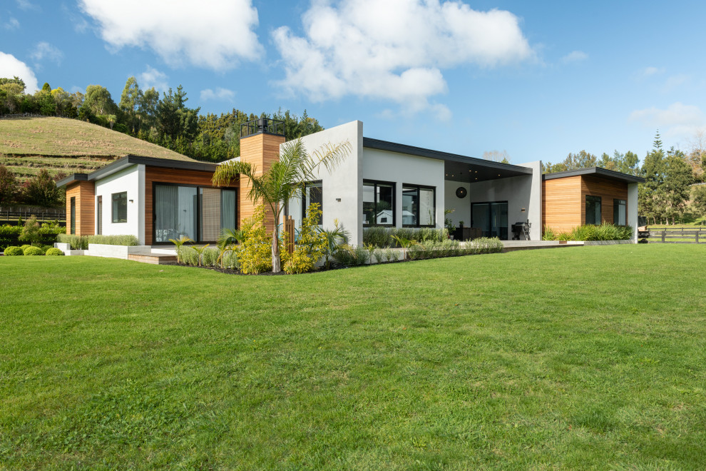 Imagen de fachada de casa multicolor contemporánea de tamaño medio de una planta con revestimiento de hormigón, tejado plano y tejado de metal