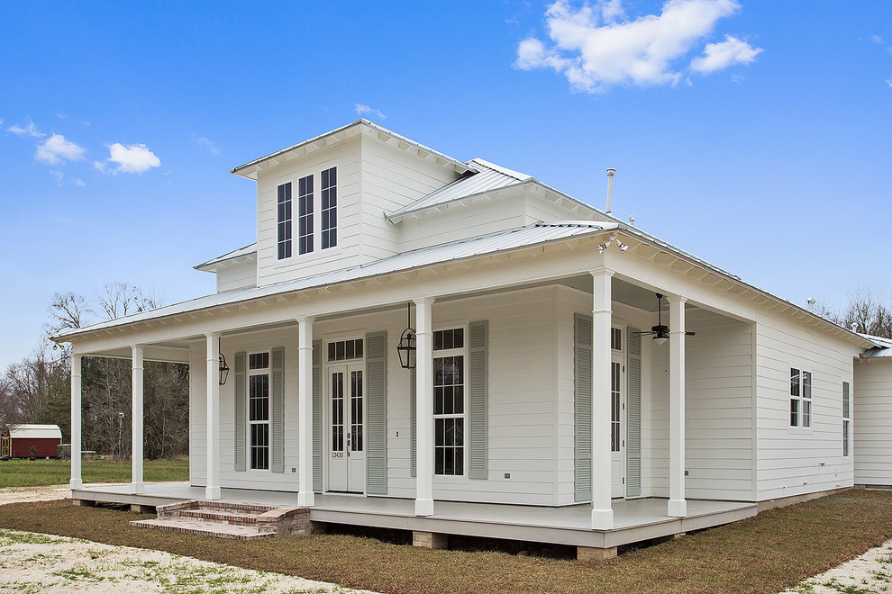 Foto della facciata di una casa bianca country a due piani di medie dimensioni con rivestimento in legno e tetto a padiglione
