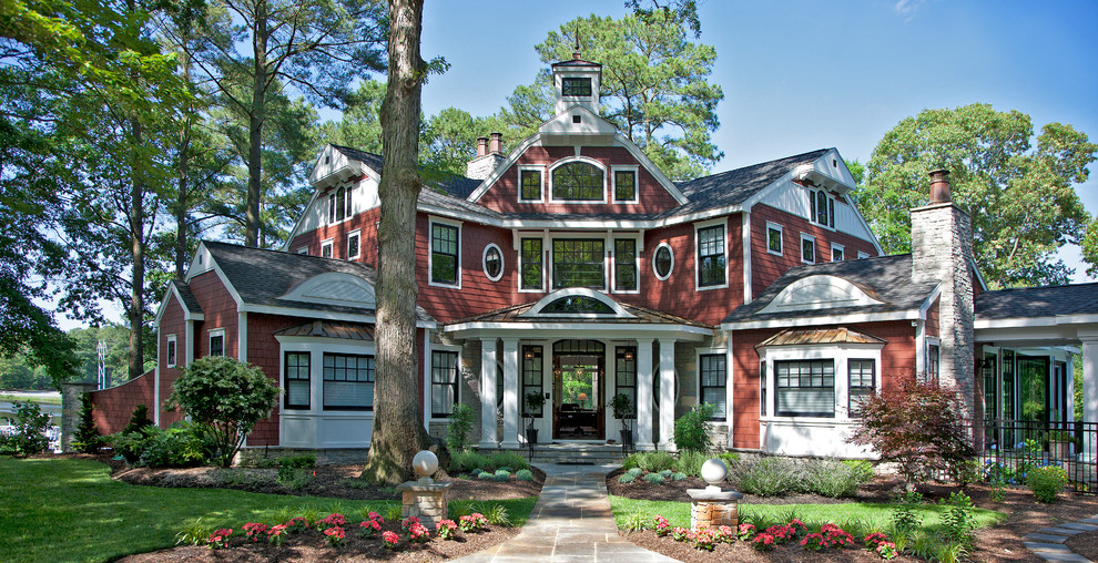 На фото: красный, большой, двухэтажный, деревянный частный загородный дом в классическом стиле с вальмовой крышей и крышей из смешанных материалов