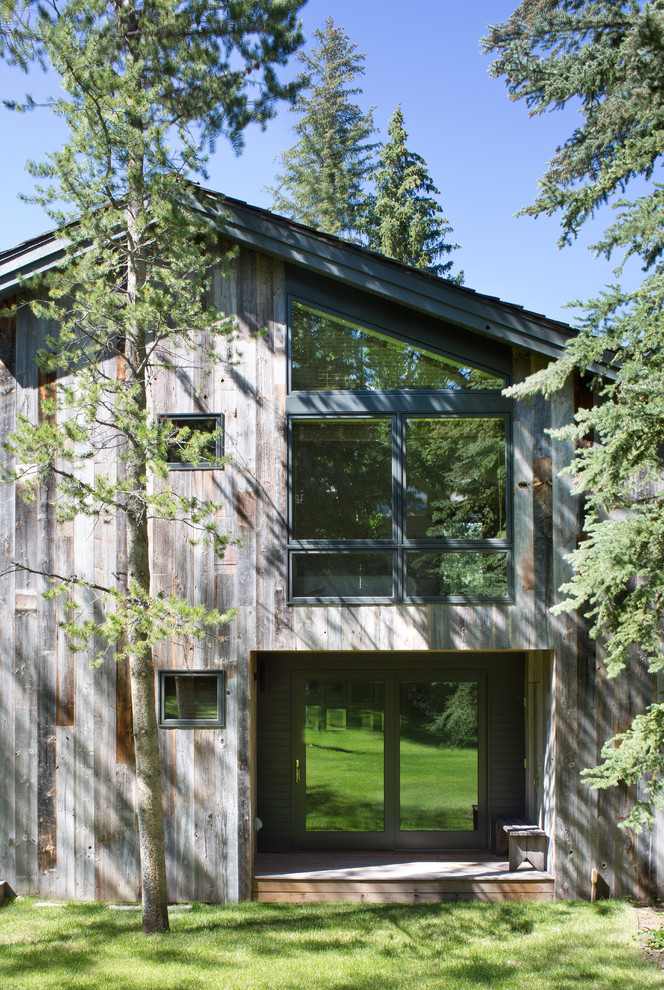 Inspiration för stora moderna grå trähus, med två våningar och pulpettak