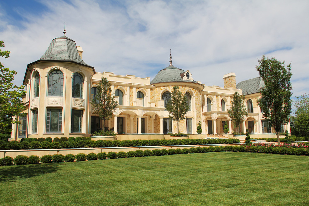 Foto della villa ampia beige classica a due piani con rivestimento in pietra e copertura a scandole