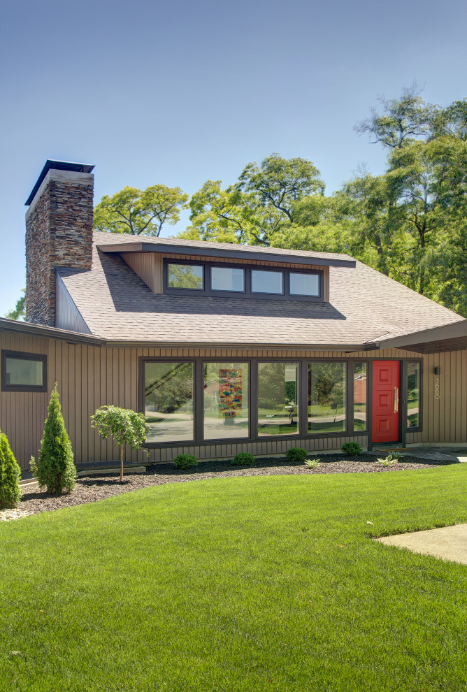 Aménagement d'une grande façade de maison marron rétro à un étage avec un revêtement en vinyle, un toit à deux pans et un toit en shingle.