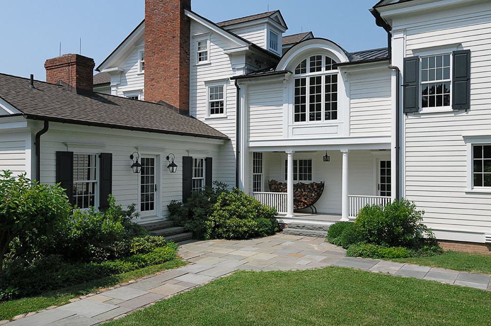Immagine della facciata di una casa bianca country con rivestimento in legno