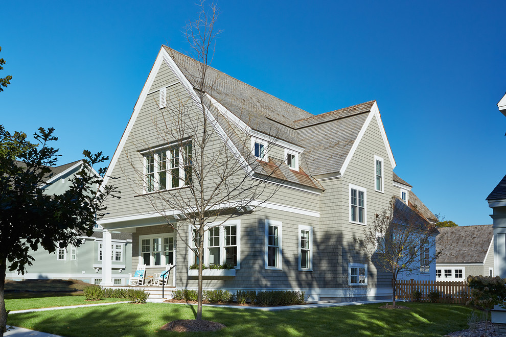 Imagen de fachada gris clásica renovada de dos plantas con revestimiento de madera y tejado a dos aguas