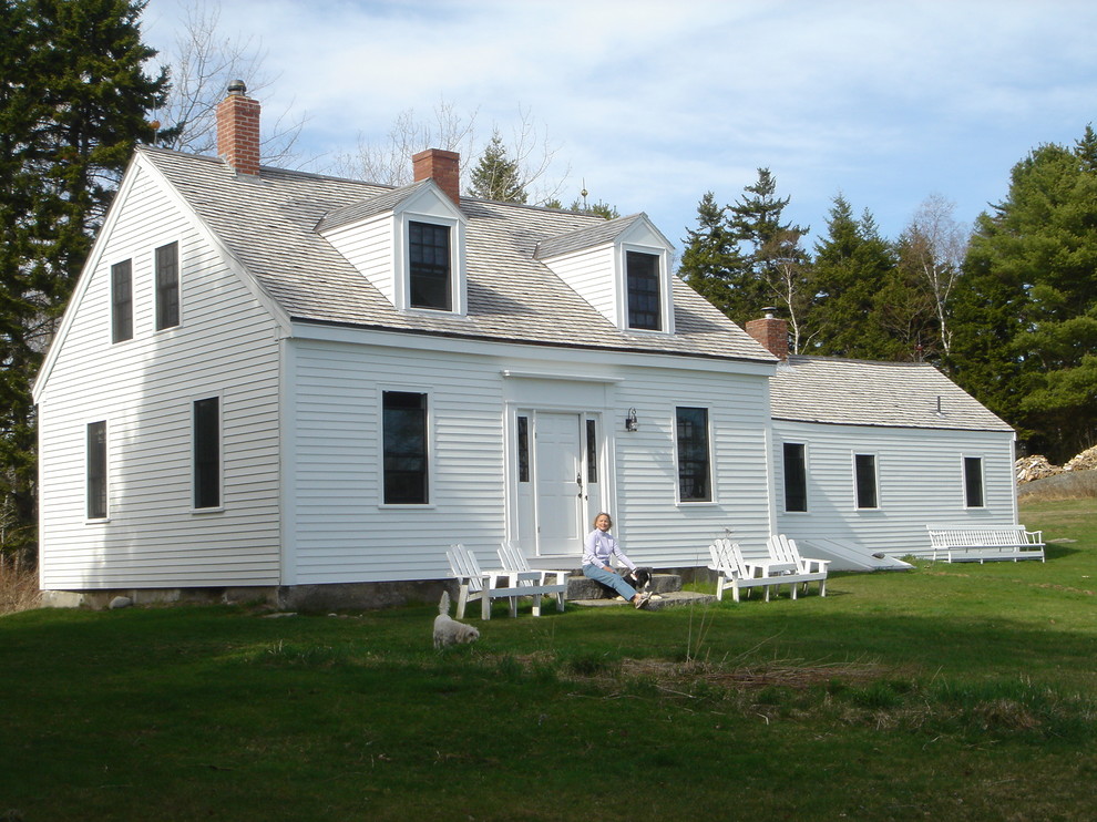 Réalisation d'une façade de maison blanche champêtre en bois de taille moyenne et à un étage avec un toit à deux pans.