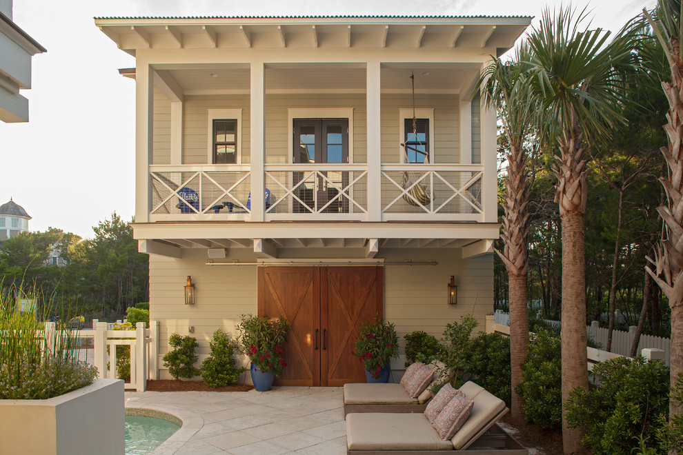 Inspiration for a coastal two floor house exterior in Miami with wood cladding.