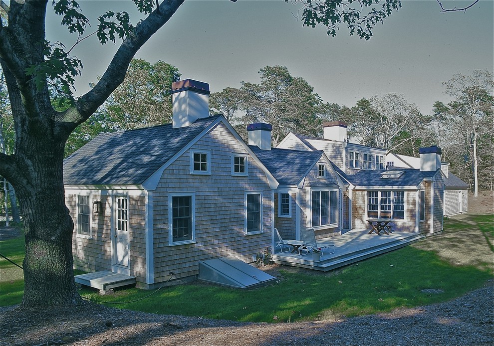 Cette photo montre une grande façade de maison marron chic en bois à un étage avec un toit à deux pans et un toit en shingle.