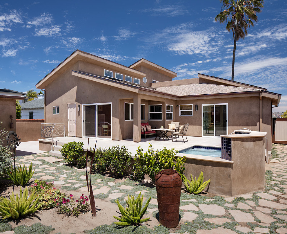 Photo of a beige and medium sized contemporary two floor concrete detached house in San Diego with a lean-to roof and a shingle roof.