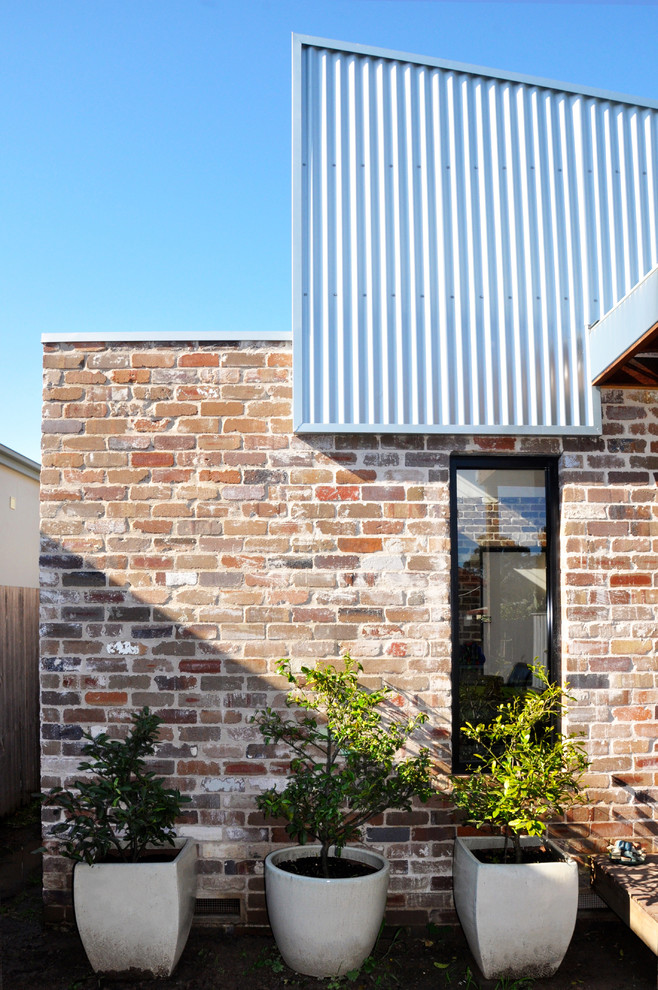 Imagen de fachada minimalista de tamaño medio de una planta con revestimiento de ladrillo