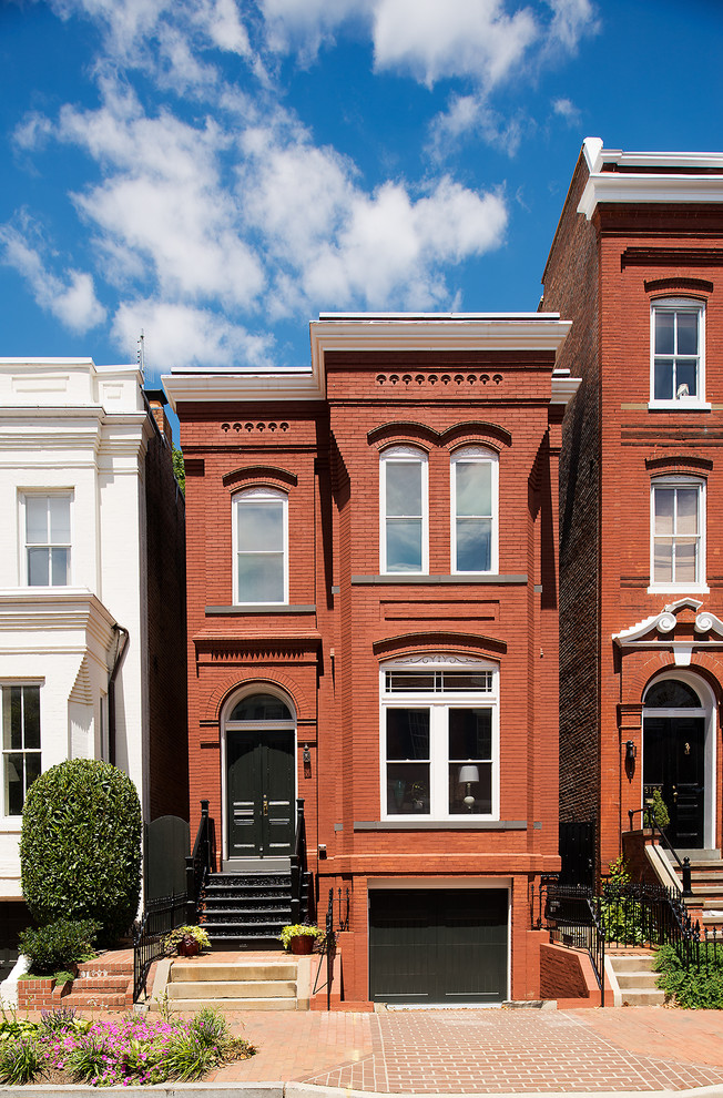 Large and red traditional brick house exterior in DC Metro with three floors.
