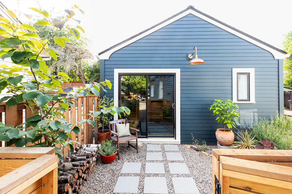 Стильный дизайн: маленький, одноэтажный, синий многоквартирный дом в стиле неоклассика (современная классика) с облицовкой из ЦСП, двускатной крышей и крышей из гибкой черепицы для на участке и в саду - последний тренд