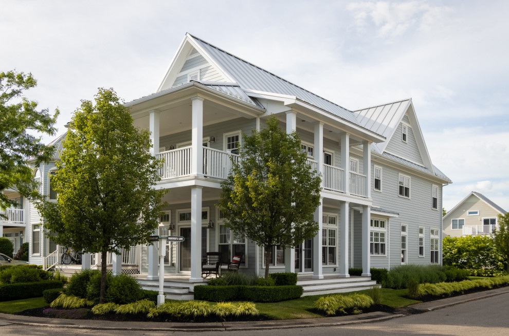 Dreistöckiges Maritimes Einfamilienhaus mit grauer Fassadenfarbe, Satteldach, Blechdach, grauem Dach und Verschalung in Sonstige