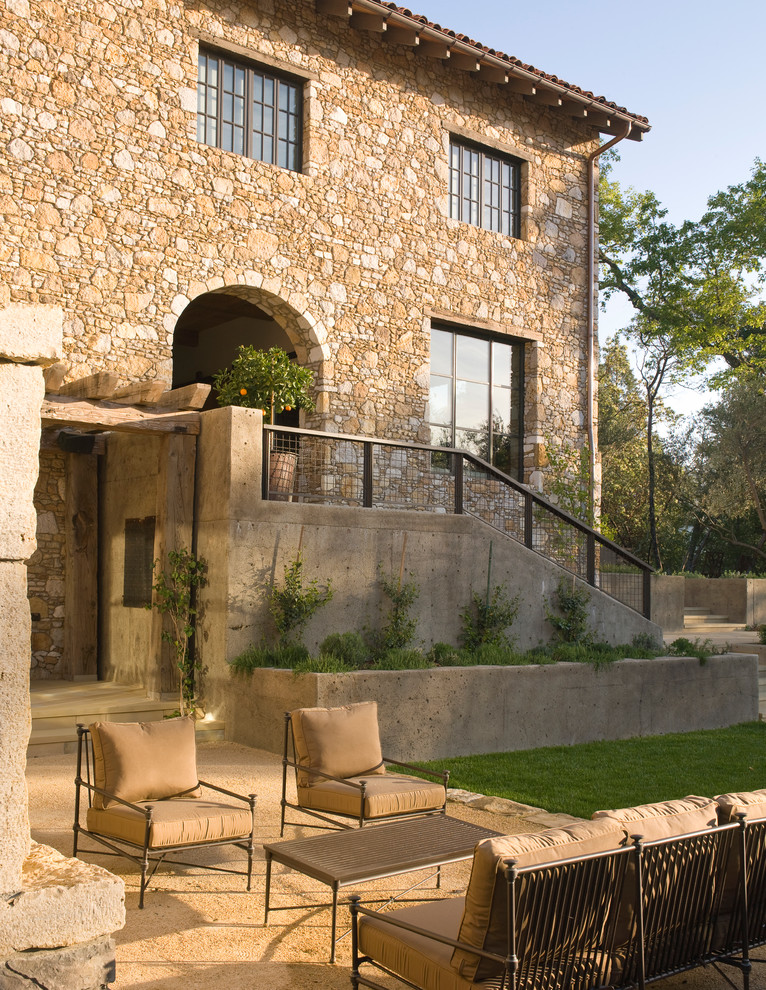 Diseño de fachada beige mediterránea de dos plantas con revestimiento de piedra
