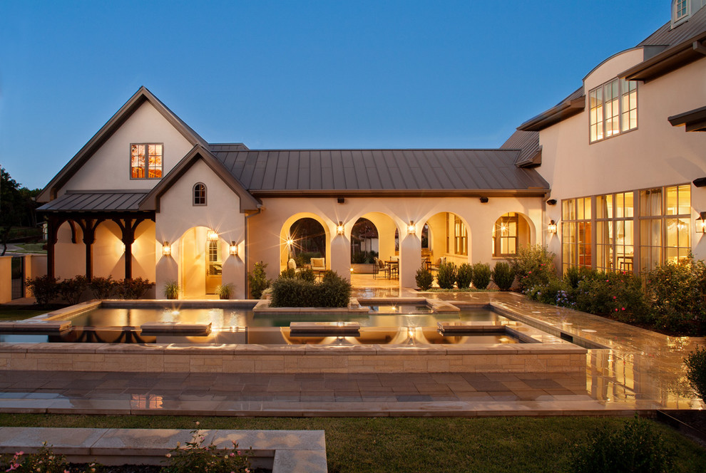 Tuscan beige two-story exterior home photo in Austin with a metal roof