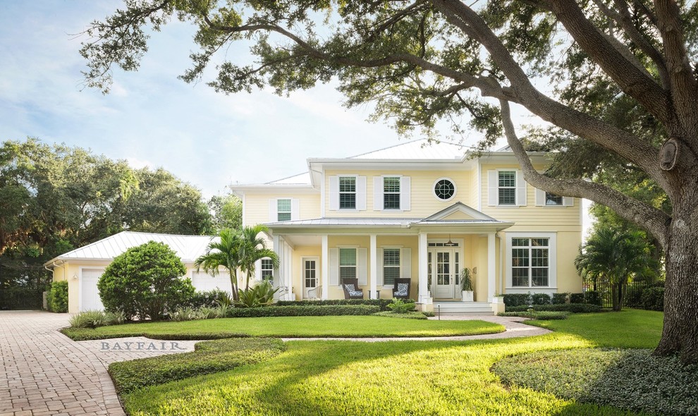 Großes, Zweistöckiges Maritimes Einfamilienhaus mit gelber Fassadenfarbe, Faserzement-Fassade, Walmdach und Blechdach in Tampa