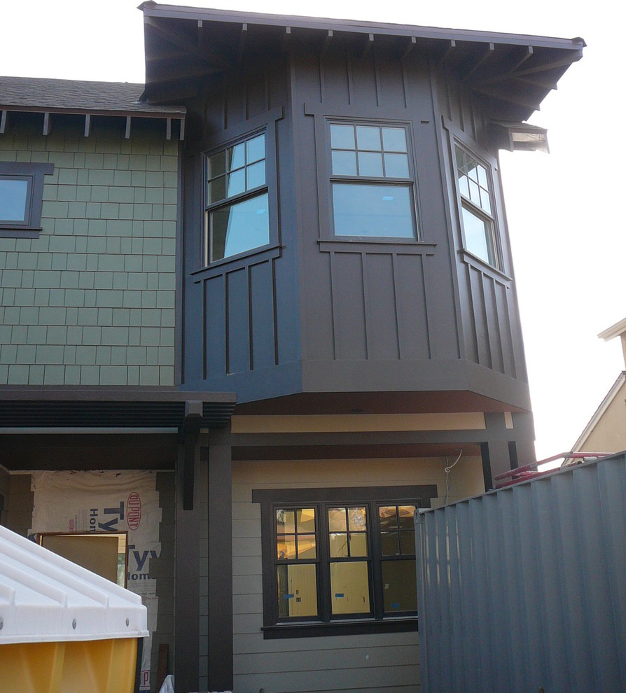 Idee per la facciata di una casa verde american style a due piani di medie dimensioni con rivestimento con lastre in cemento e tetto a capanna