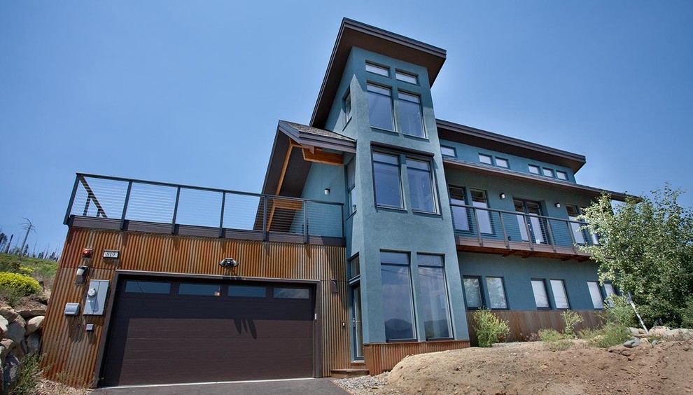 Aménagement d'une façade de maison bleue industrielle en béton de taille moyenne et à deux étages et plus avec un toit plat.
