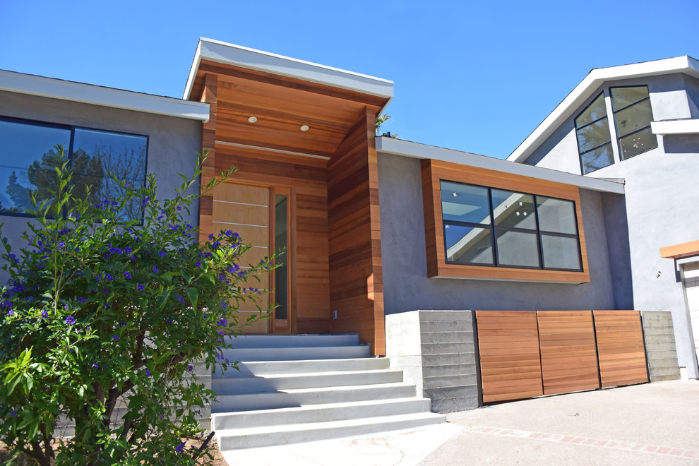 Стильный дизайн: большой, двухэтажный, серый дом в стиле модернизм с комбинированной облицовкой и двускатной крышей - последний тренд