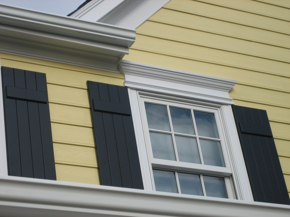 Пример оригинального дизайна: большой, двухэтажный, деревянный, желтый дом в классическом стиле с двускатной крышей