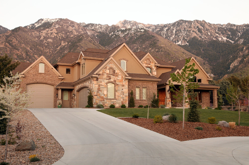 Inspiration for a large and beige traditional house exterior in Salt Lake City with three floors and mixed cladding.