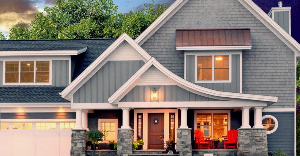 Cette image montre une grande façade de maison bleue design en bois à un étage avec un toit à deux pans.