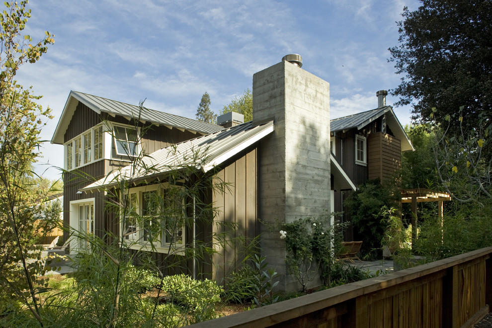 Cette photo montre une façade de maison chic en bois de taille moyenne et à un étage avec un toit en métal.