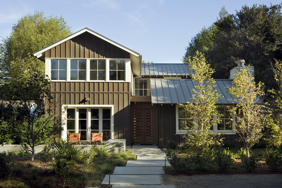 Réalisation d'une façade de maison marron tradition en bois de taille moyenne et à un étage.