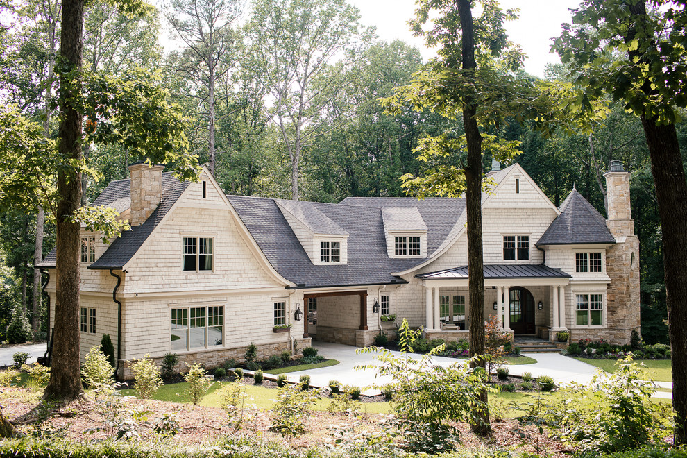Inspiration pour une grande façade de maison beige traditionnelle en bois à un étage avec un toit à quatre pans et un toit en shingle.