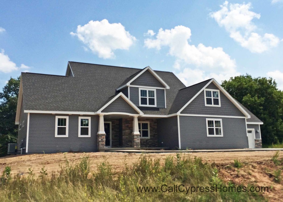 Example of a mid-sized classic gray two-story vinyl exterior home design in Other