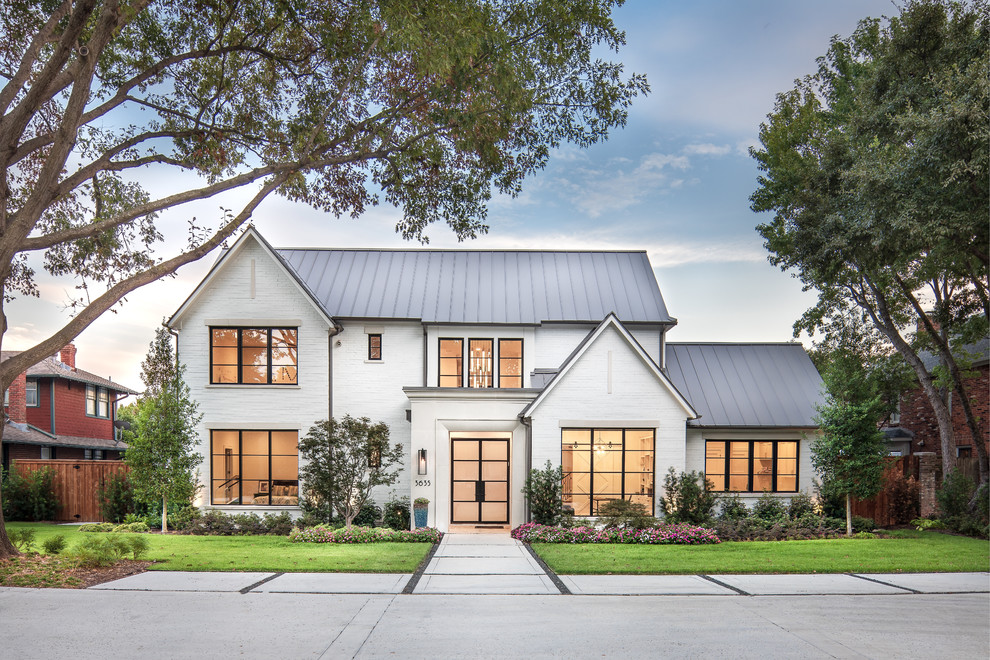 Zweistöckiges Landhaus Einfamilienhaus mit Backsteinfassade, weißer Fassadenfarbe, Satteldach und Blechdach in Dallas