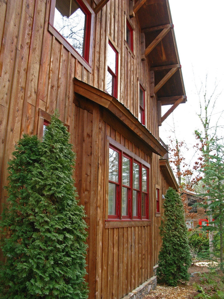 Imagen de fachada marrón rural grande de tres plantas con revestimiento de madera y tejado a dos aguas