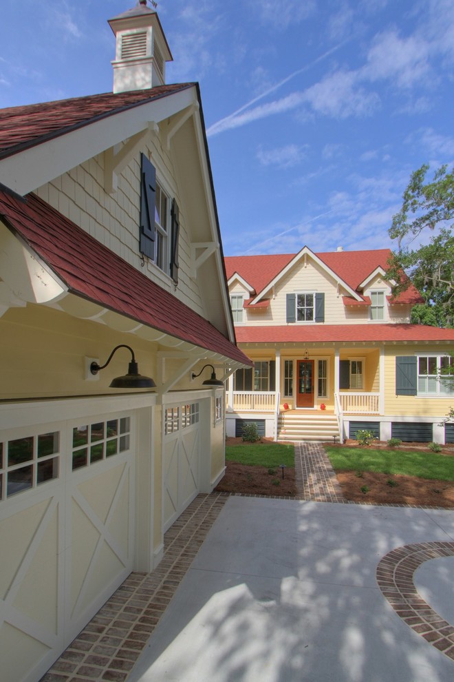 Aménagement d'une grande façade de maison jaune campagne en bois à un étage avec un toit à deux pans.