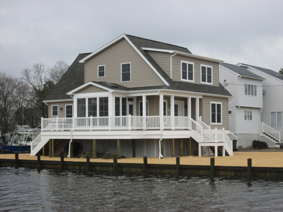 This is an example of a beige coastal two floor house exterior in New York with concrete fibreboard cladding.