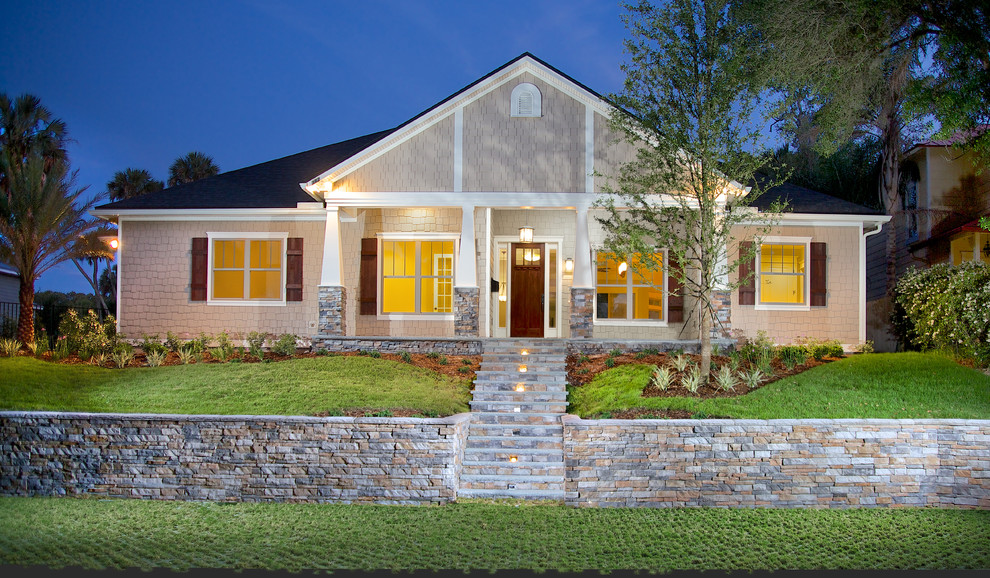 Example of a mid-sized arts and crafts beige one-story wood exterior home design in Jacksonville with a shingle roof