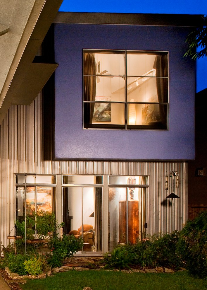 Diseño de fachada de casa azul actual de tamaño medio de dos plantas con revestimiento de metal, tejado a dos aguas y tejado de metal