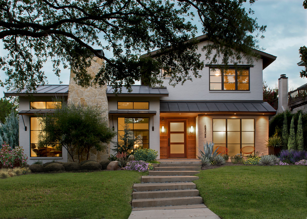 Photo of a medium sized traditional two floor house exterior in Austin with a pitched roof and a metal roof.