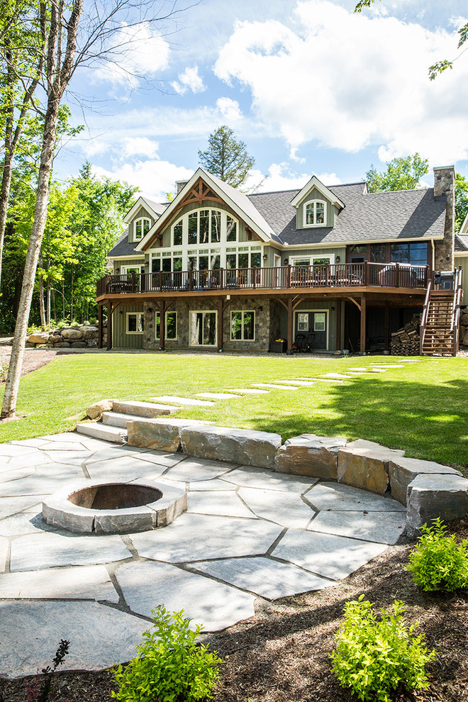 Cette photo montre une grande façade de maison verte montagne en bois avec un toit à deux pans.