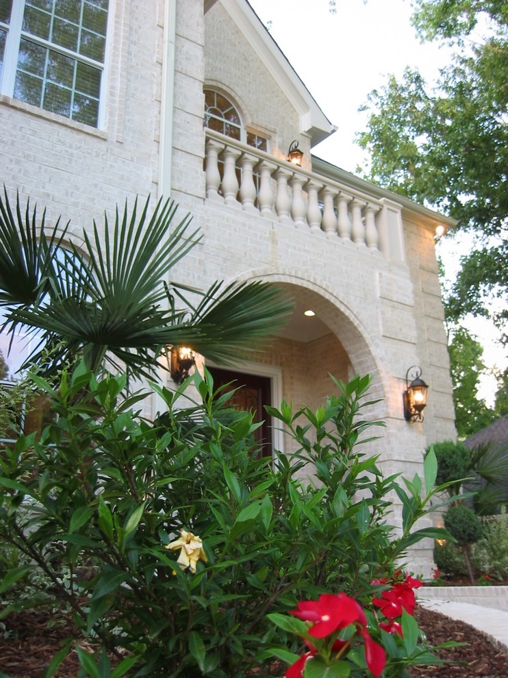 This is an example of a white and medium sized mediterranean two floor brick detached house in Austin.