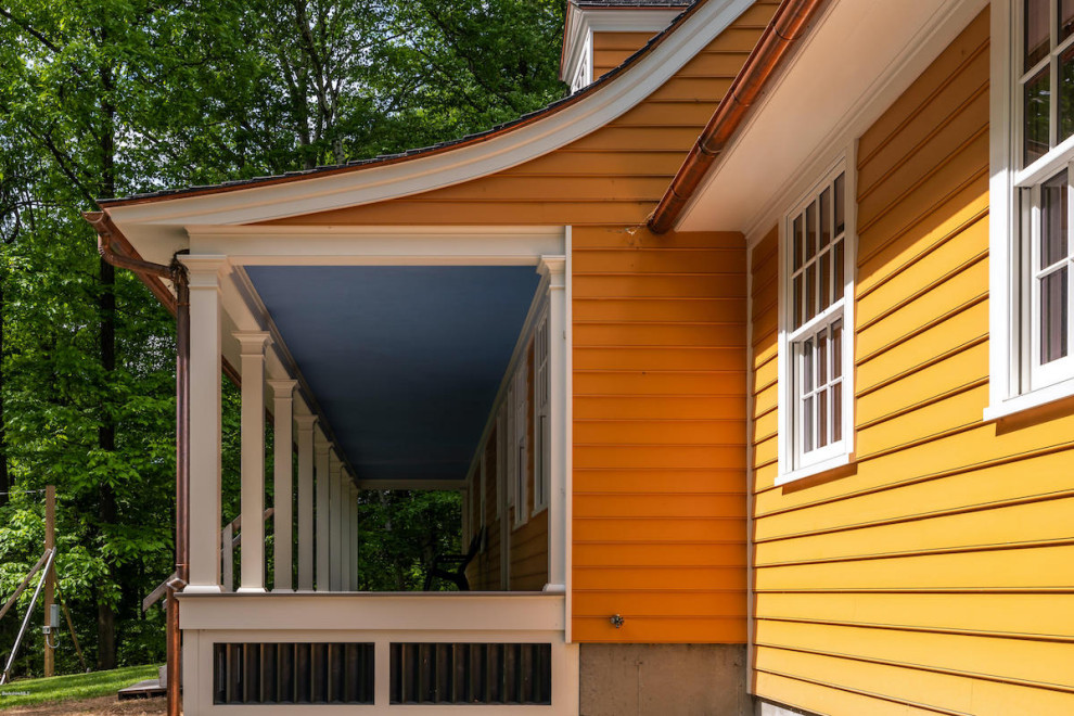 Пример оригинального дизайна: большой, трехэтажный, деревянный, оранжевый частный загородный дом в классическом стиле