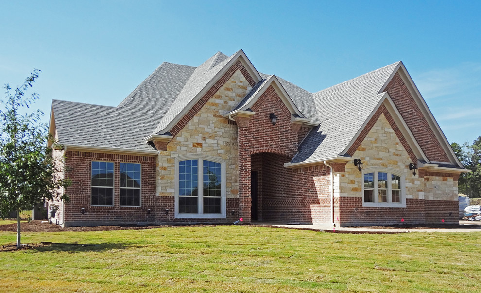 Photo of a large and red classic two floor brick detached house in Dallas with a hip roof and a shingle roof.