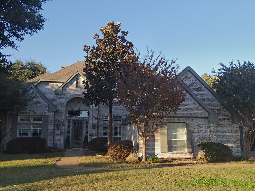 Large traditional white two-story brick gable roof idea in Dallas