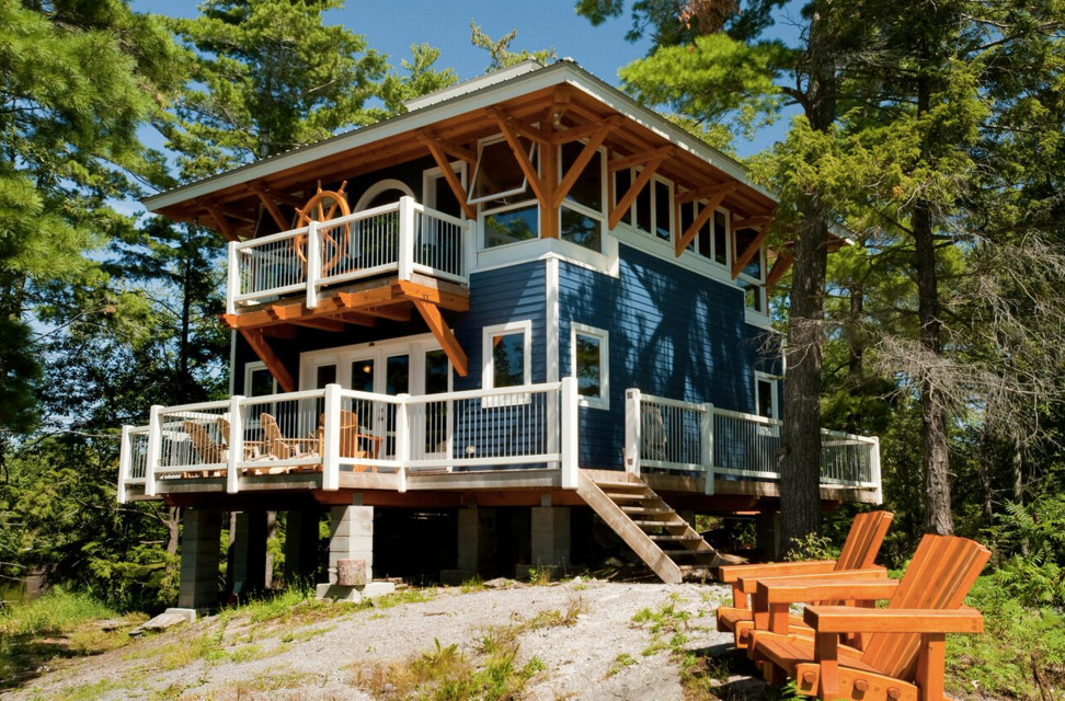 На фото: двухэтажный, синий дом среднего размера в морском стиле с облицовкой из винила и плоской крышей