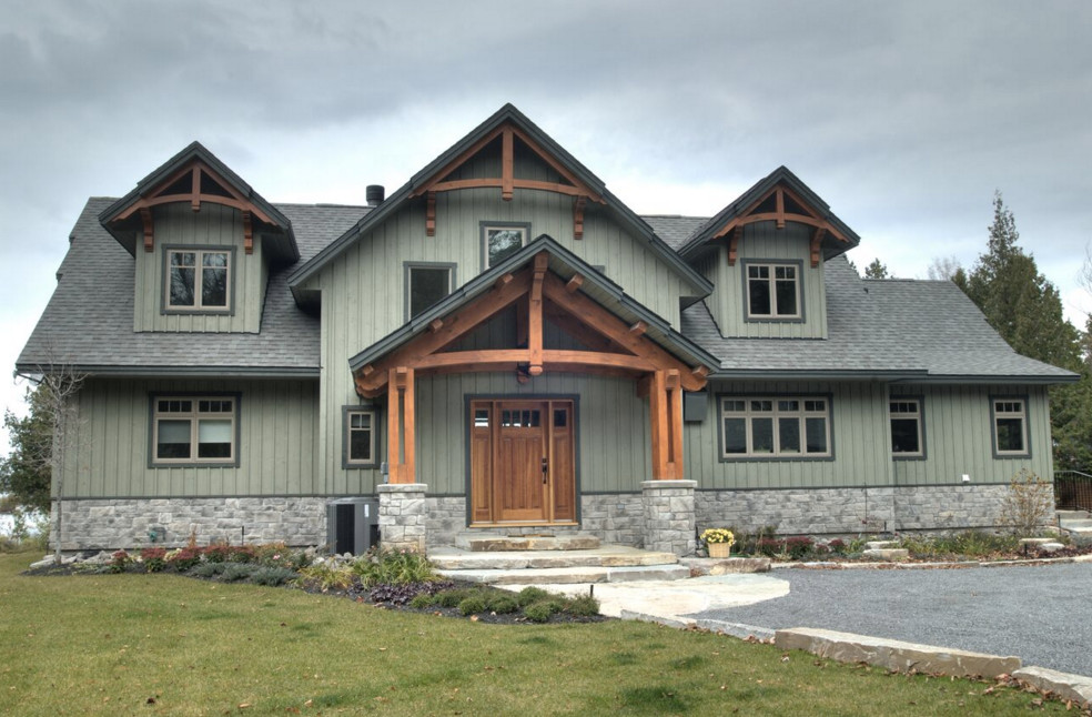 Cette photo montre une façade de maison verte craftsman de taille moyenne et à un étage avec un revêtement en vinyle et un toit à deux pans.