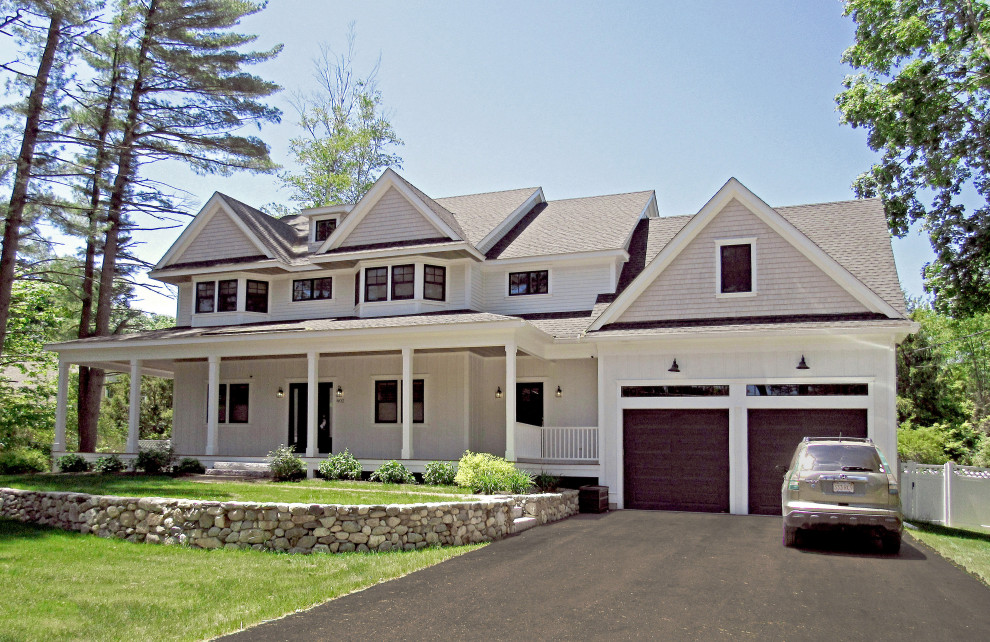 Imagen de fachada de casa blanca campestre grande de dos plantas con revestimientos combinados, tejado a dos aguas y tejado de teja de madera