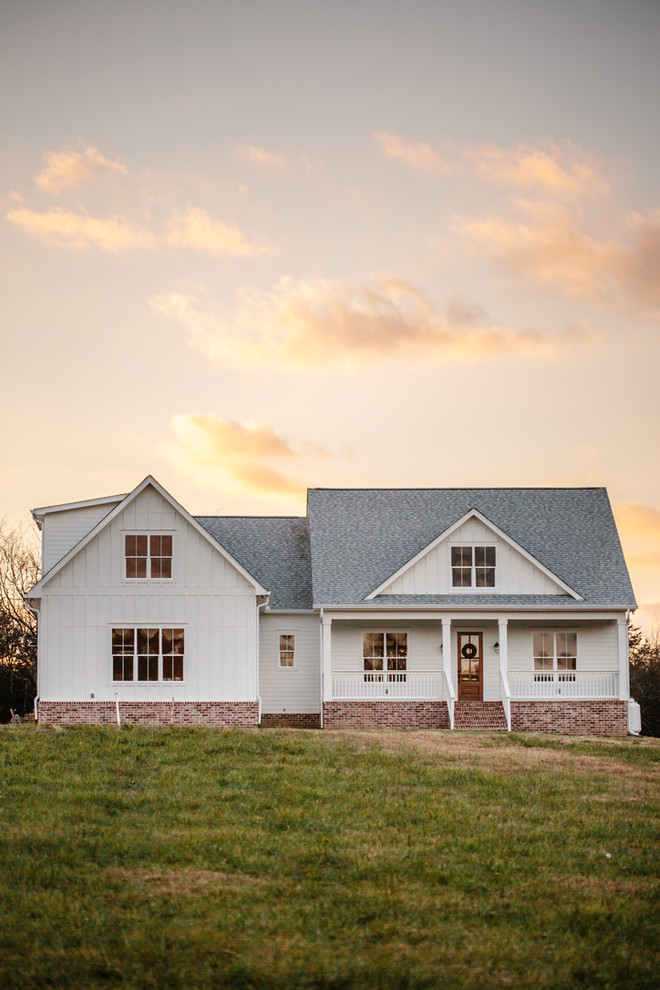 This is an example of a large and white country two floor detached house in Nashville with concrete fibreboard cladding, a pitched roof and a shingle roof.