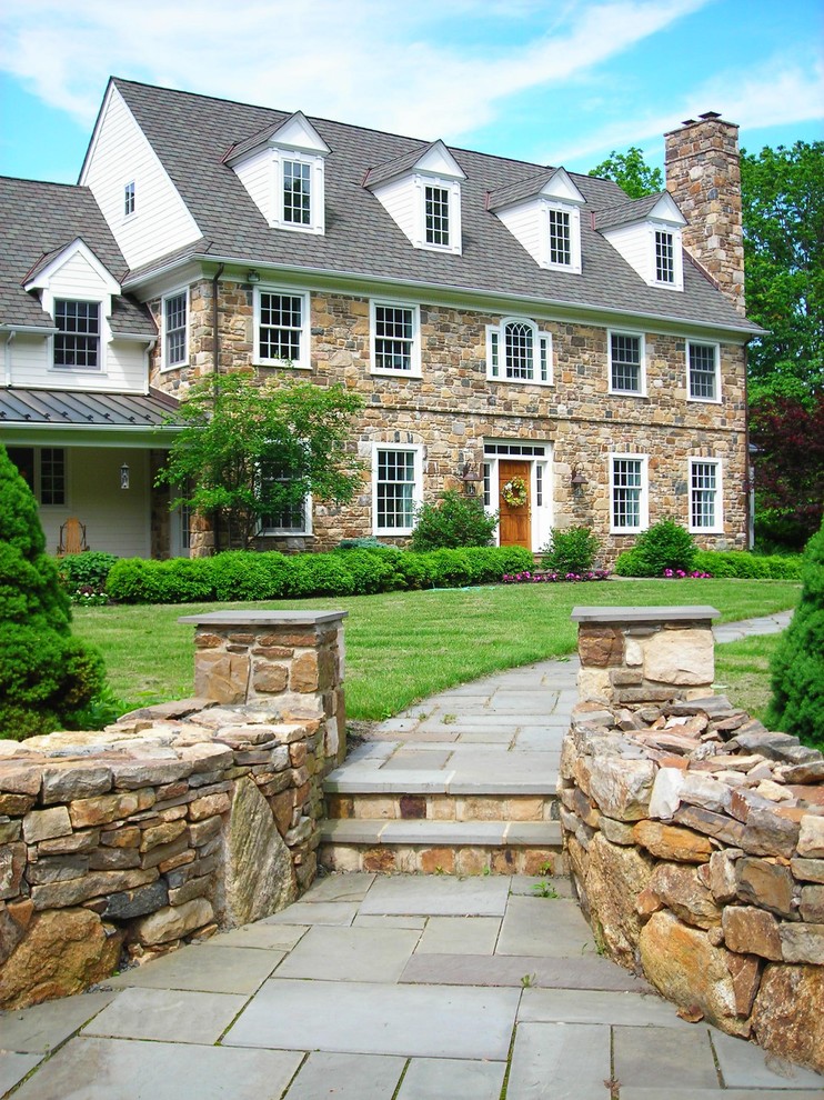 Immagine della facciata di una casa grande classica a tre piani con rivestimento in pietra