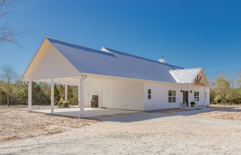 Esempio della villa bianca country a un piano di medie dimensioni con rivestimento in legno, tetto a padiglione e copertura in metallo o lamiera