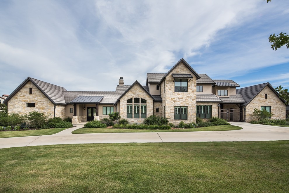 Inspiration for a transitional beige two-story stone gable roof remodel in Austin