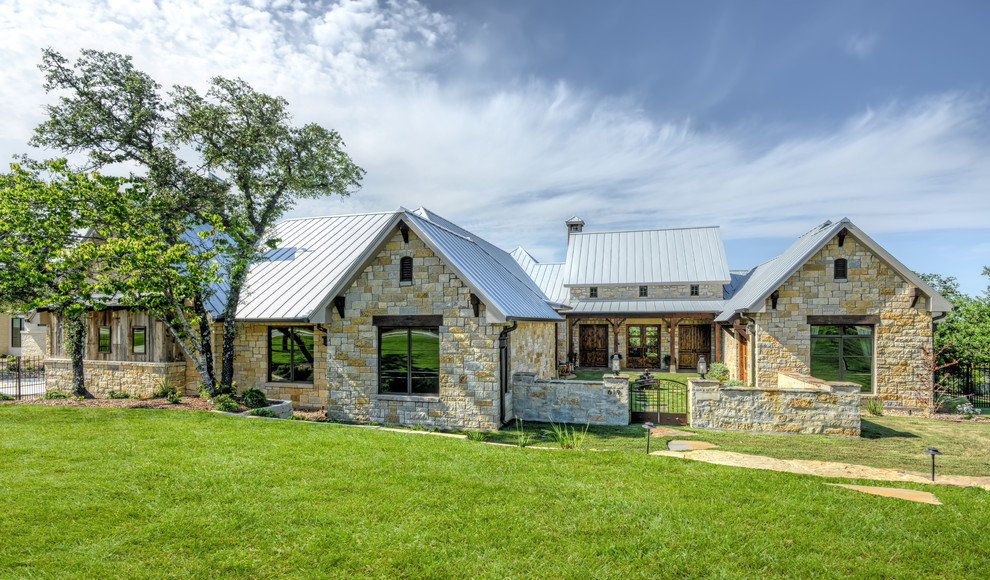 Example of a transitional one-story stone exterior home design in Austin with a metal roof