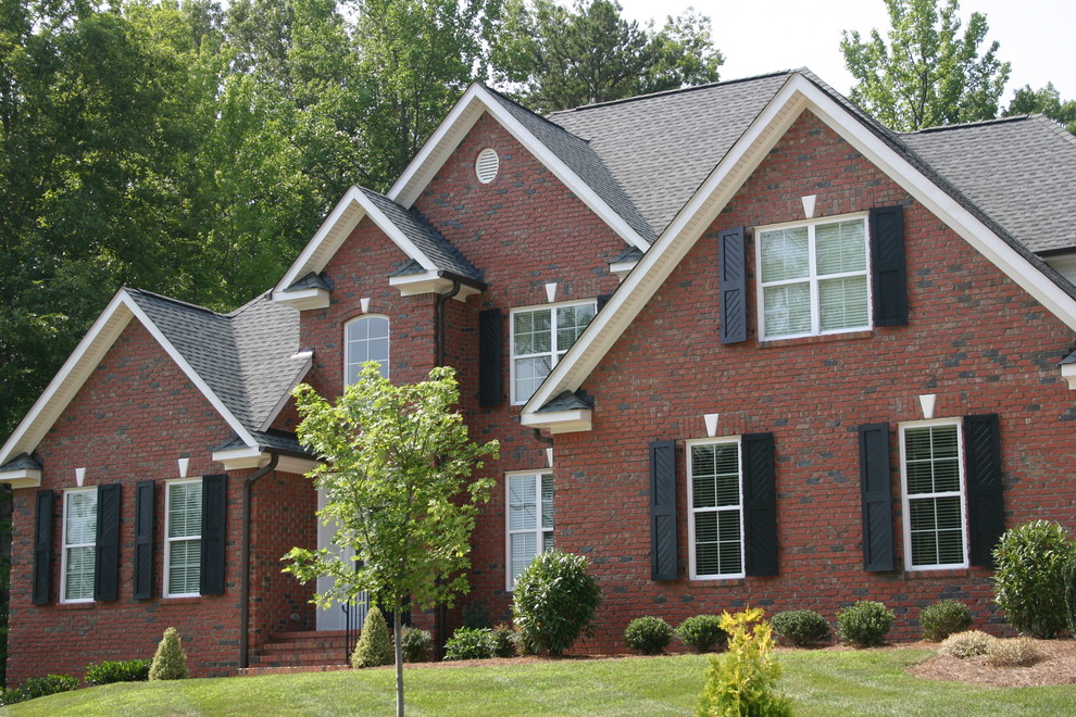 Inspiration for a large timeless two-story brick gable roof remodel in Other